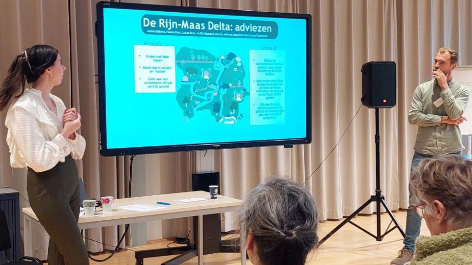 Deelnemers geven een presentatie op een projector op de slotdag van het leerwerktraject